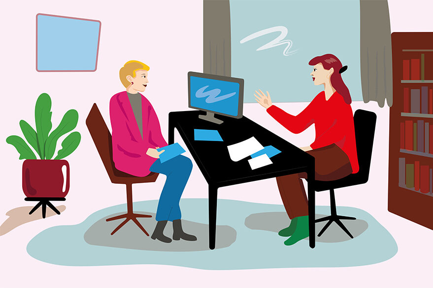 Das Bild zeigt eine Beratungssituation in einem Büro. Zwei Frauen sitzen sich an einem Schreibtisch gegenüber.